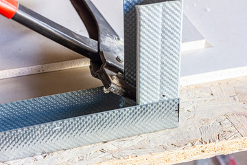 eine Verbundzange wird an Aluminiumschiene benutzt