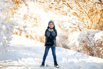 Fototapeta na wymiar Winter portrait of a child in a beautiful snowy winter park