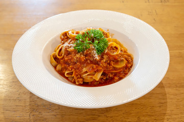 Spaghetti with white disc on wooden table