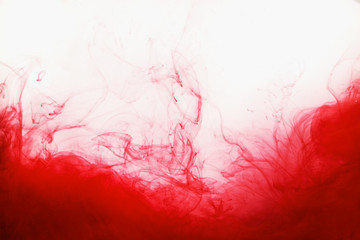 Red ink in the water abstract grunge paint swirl isolated on white background. Blood concept with...