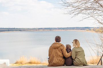 Fototapeta premium young beautiful family sitting at beach with view lake