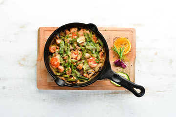 Baked beef with beans, tomatoes and vegetables in a frying pan. Top view. Free space for your text.