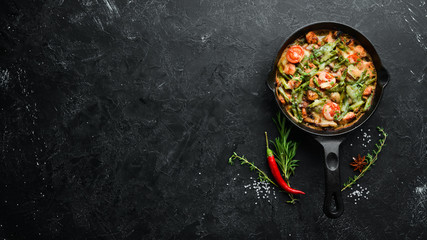 Baked beef with beans, tomatoes and vegetables in a frying pan. Top view. Free space for your text.