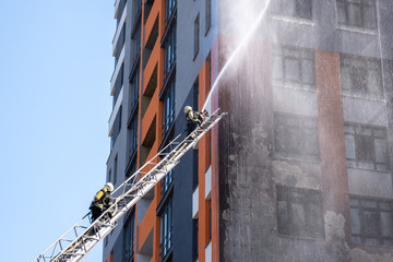 fireman climbing a ladder with water hose for extinguish fire