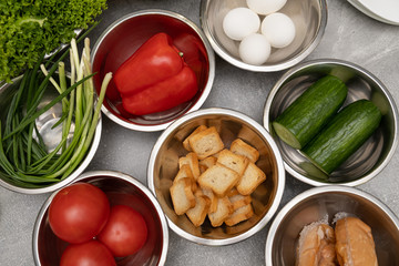 Cut vegetables, salad ingredients on plates. preparation for cooking caesar salad