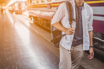 Young man traveling backpacker in train station.travel concept.