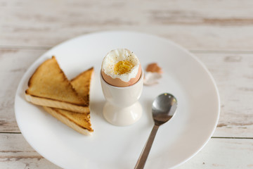Hard boiled egg and bread sandwich with sprouted grain on a wooden table. Traditional food for healthy breakfast.
