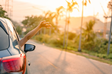 Happy woman Driving on Country Road into the Sunset