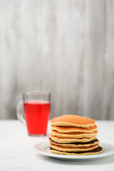 Homemade pancakes and compote on a light background.