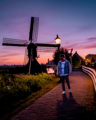 men watching Sunrise at the Zaanse Schans windmill village in the Netherlands, zaanse schans is a small wooden house village in Holland, Dutch windmills