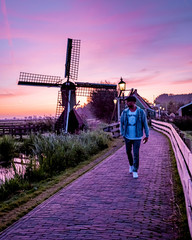 men watching Sunrise at the Zaanse Schans windmill village in the Netherlands, zaanse schans is a small wooden house village in Holland, Dutch windmills