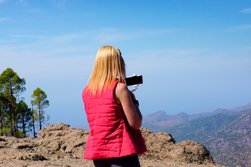 woman on top of the mountain taking a selfie