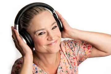 Middle Aged woman in 40s happy listening to music on wireless bluetooth headphones
