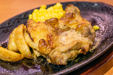 Chicken, French fries, and corn in plate