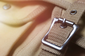 Closeup of quality brown messenger bag with belt made of sackcloth in vintage tone and look and metal buckle for fashion and casual accessories.