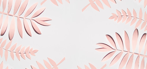 Fototapeta na wymiar Flat lay pink paper palm leaves on gray background. Summer frame mockup. Copy space