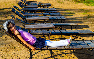 child 6-7 years old sunbathes on the beach