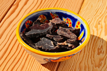 Biltong (dried meat) on a wooden board, this is a traditional food snack that can be found in South...