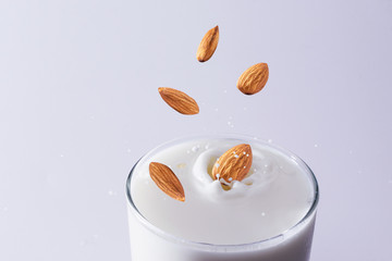 Closeup milk splash with almonds nut  on white background.