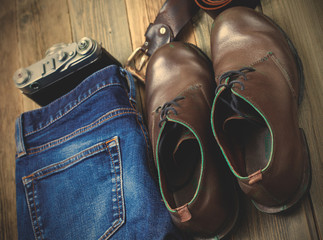 blue jeans, brown boots, leather belt and rangefinder camera