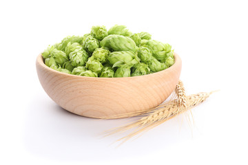 Spikelets and wooden bowl with hop isolated on white background