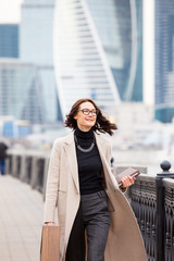 attractive middle-aged woman in a light coat smiles
