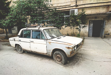 Abandoned car with punctured tires in a residential area