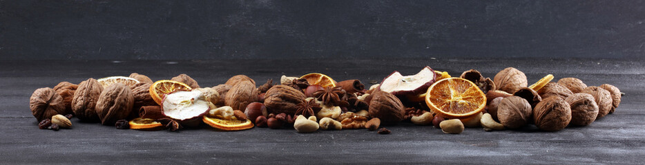 Composition with dried fruits and assorted healthy nuts on rustic background for christmas
