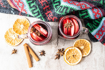 Hot aromatic mulled wine with honey, spices and fruits on the table top view. Traditional aromatic Christmas drink.