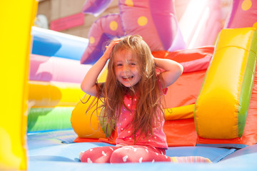 A cheerful child plays in an inflatable castle