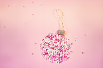 Colorful sprinkles on a pink background, top view with copy space