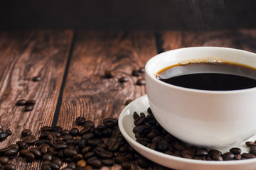 Coffee cup and coffee bean on the wooden table