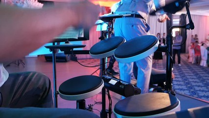 Man playing drums in a musical group, live performance. Drummer on stage. Close-up