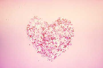 Colorful sprinkles on a pink background, top view with copy space