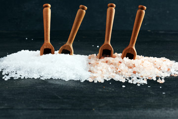 Sea salt and himalayan on spoon. Crystals of salt on dark background