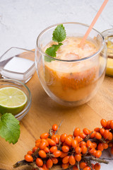fresh vegetarian fruit smoothie on wooden tray with fresh  bananas, sea buckthorn, lime, melissa and coconut milk . Healthy breakfast. close up