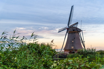Dutch windmill reflected on the early sunset lights