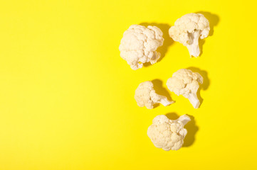 Vegetarian healthy food concept, dieting. Fresh white cleaned cauliflower on yellow background.