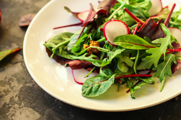 salad with radishes and mix lettuce leaves, appetizer, snack. food background. top view