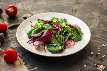 salad with radishes and mix lettuce leaves, appetizer, snack. food background. top view
