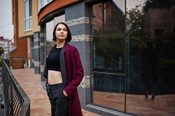 A tall leggy young beautiful and elegant model woman at claret coat.