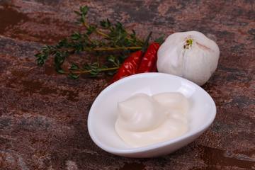 Mayonnaise sauce in the white bowl served thyme and garlic