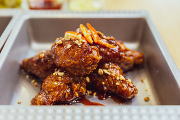 Close-up Golden Crunchy Korean Fried Chicken (basic Huraideu-Chikin) mix with spicy sauce and garlic. In South Korea, fried chicken is consumed as a meal, an appetizer.