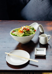 Japanese salad with avocado, tomato, green oak, almond and sesame topping sesame salad dressing.