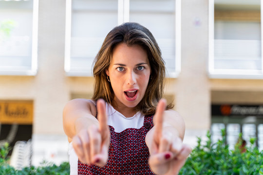 Portrait of young woman making a hand sign, wagging finger