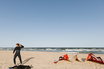 A surfer putting on a wetsuit