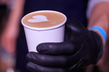 Barista ofreciendo un café decorado con espuma
