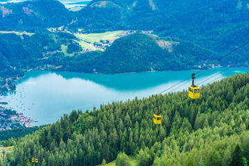 View of  Wolfgangsee lake, surrounding mountains and yellow Seilbahn cable car gondola from Zwolferhorn mountain in St. Gilgen in Salzkammergut region, Austria © beataaldridge