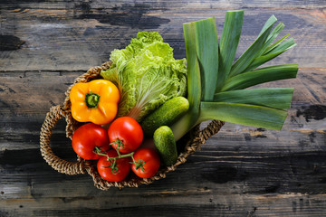 Bunch of mixed organic fruits, vegetables & greens, gourmet pile in full eco friendly shopping bag to reduce ecological footprint. Zero waste concept. Wood table background, copy space, close up.