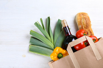 Bunch of mixed organic fruits, vegetables & greens, gourmet pile in full eco friendly shopping bag to reduce ecological footprint. Zero waste concept. White table background, copy space, close up.